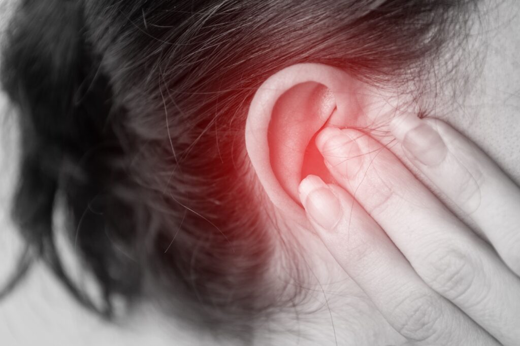 Woman holding her ear.